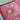 Gold star-shaped necklace on a pink velvet surface
